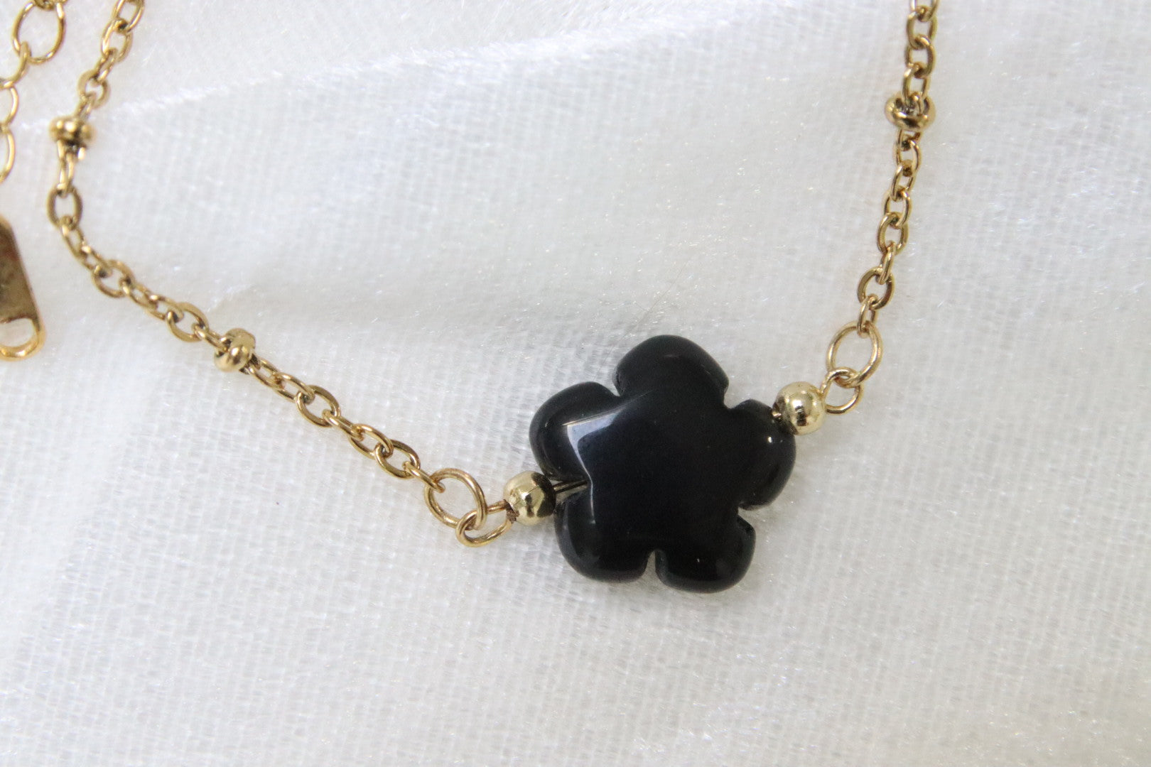 Gros plan sur bracelet en onyx noir en forme de fleur.