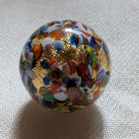 Une perle de Murano, aux multiples couleurs rappelant le déguisement d'Arlequin