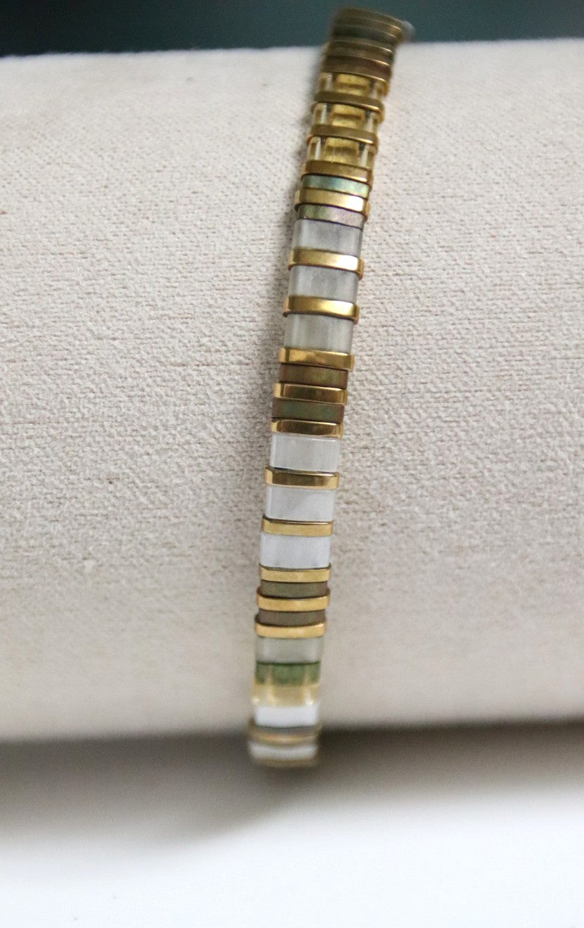 Zoom sur les détails du bracelet Sei, perles aux reflets translucides verts et jaunes rappelant l’éclat naturel.