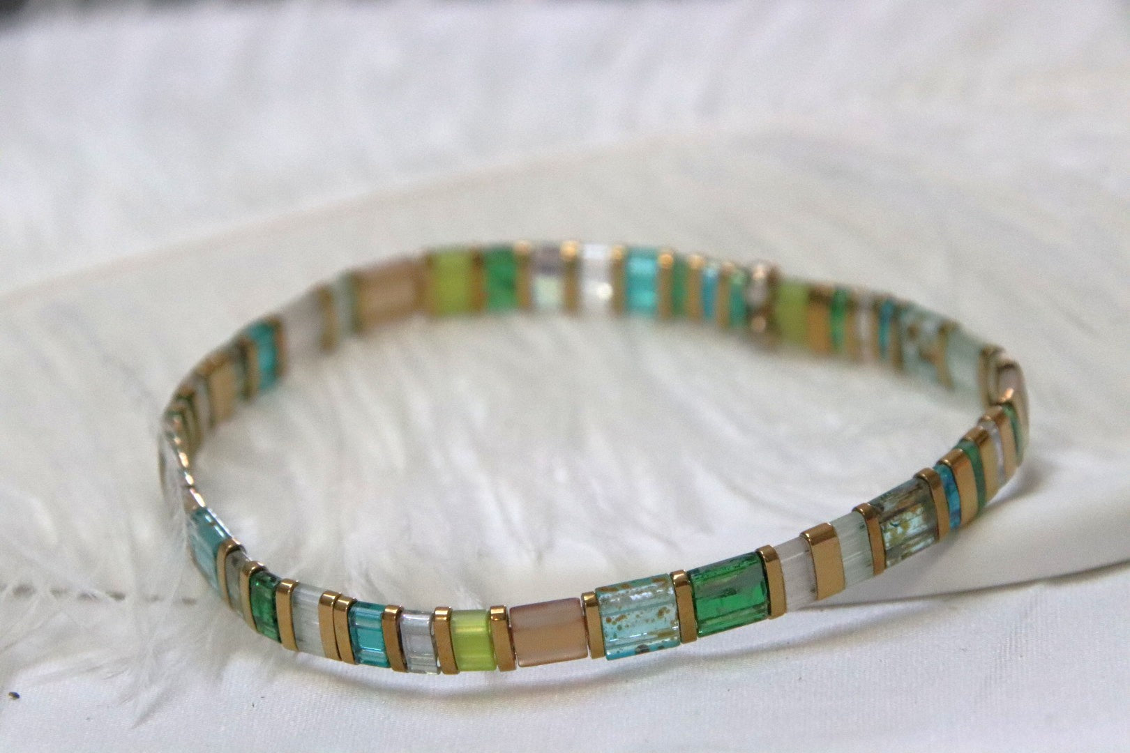 Bracelet Sui en perles transparentes bleu, vert et topaze avec touches dorées, inspiré par la pureté de l’eau.