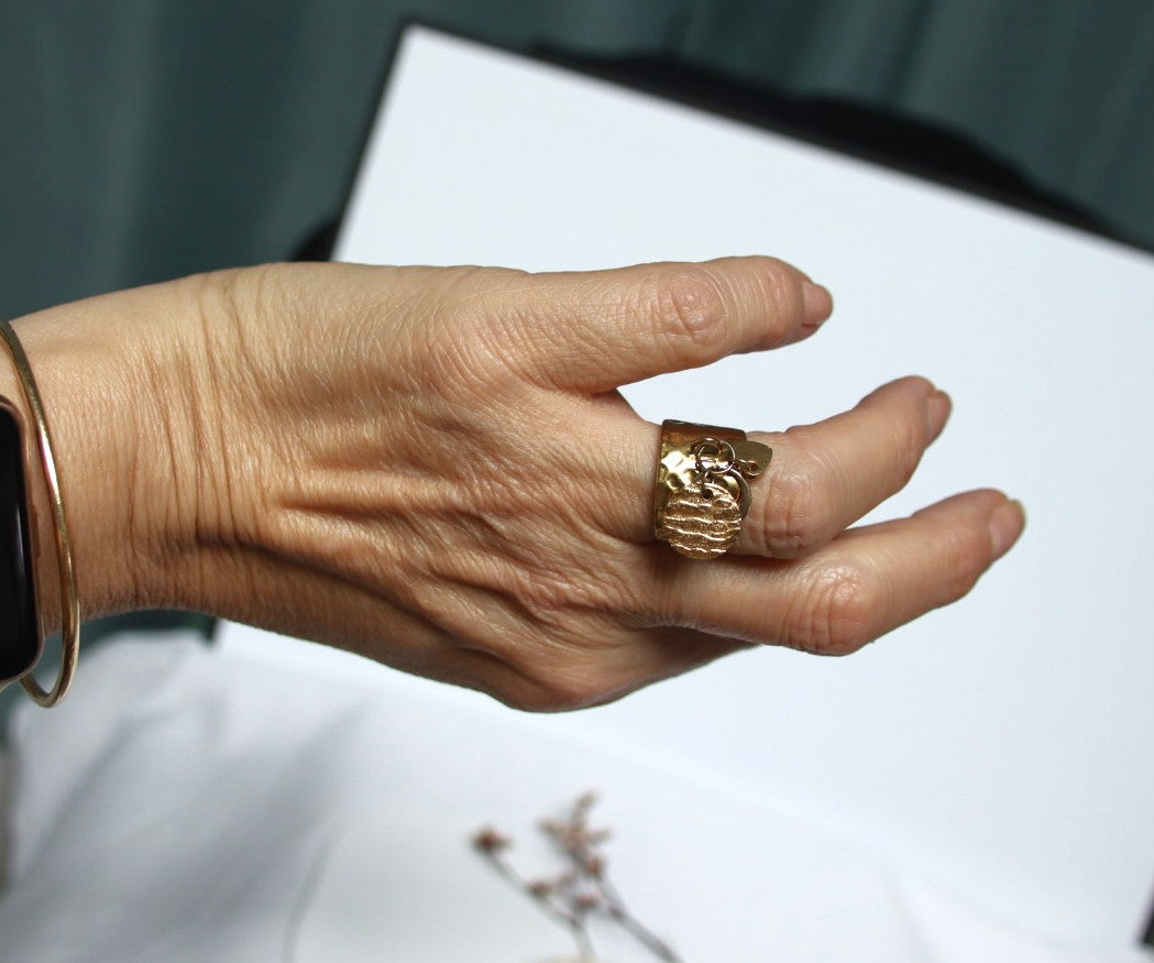 bague dorée ajustable martelée portée au doigt