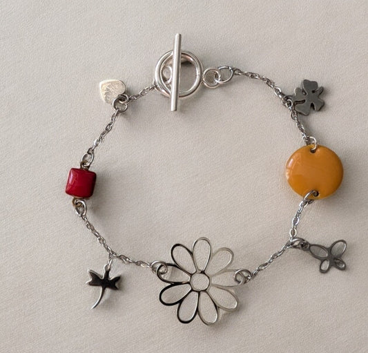 Gros plan sur le bracelet Floréale, mettant en valeur ses motifs floraux éclatants et son fermoir toggle en acier inoxydable.