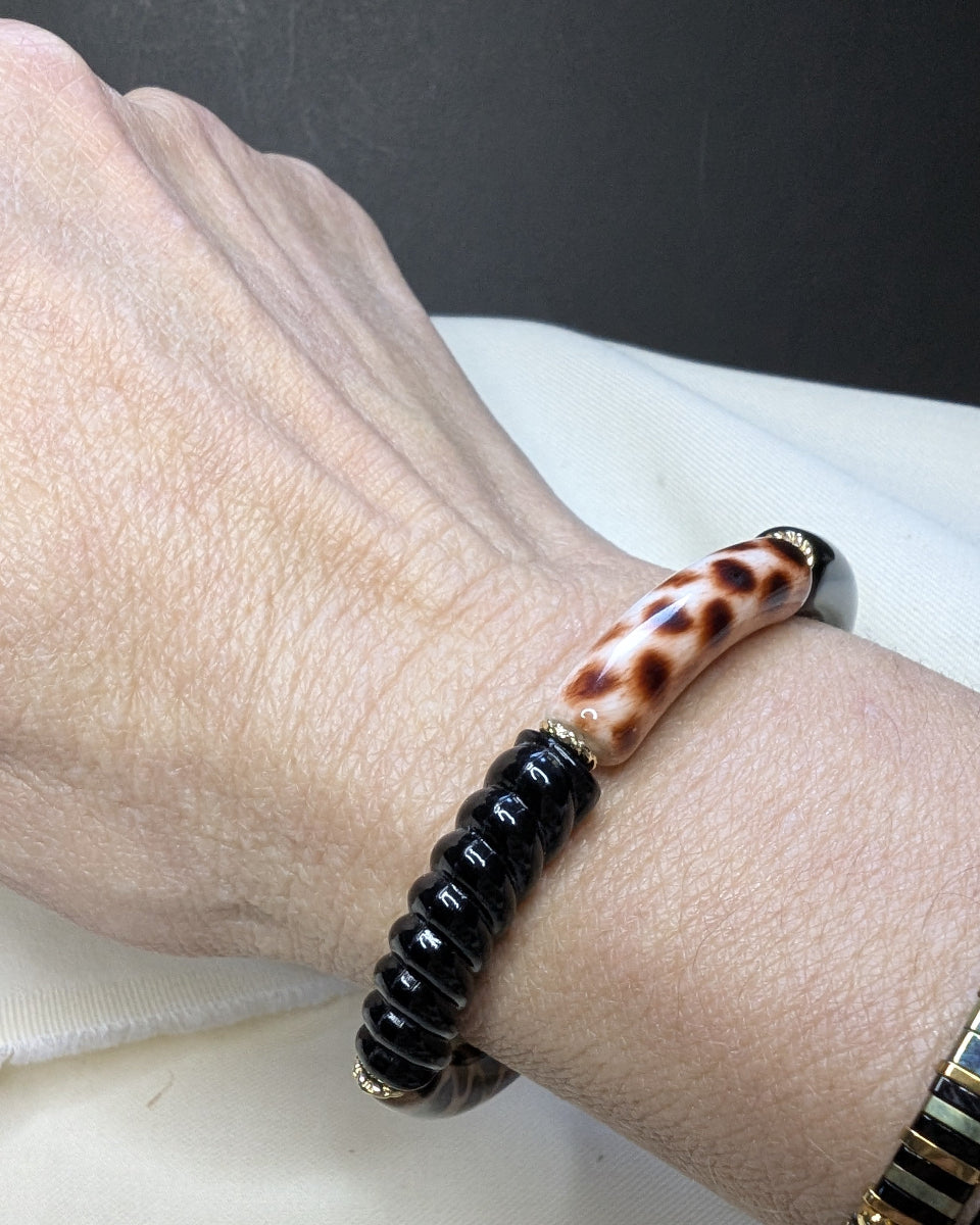 Bracelet élastique en perles de résine – noir et tacheté, au poignet