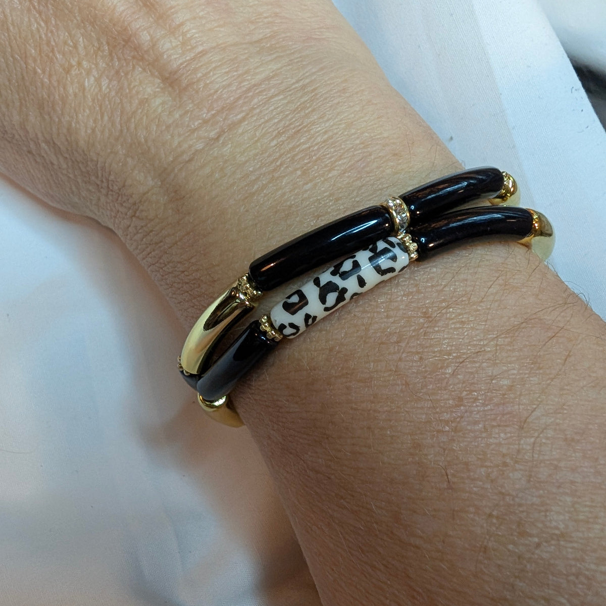 Association de deux bracelets fins en résine au poignet