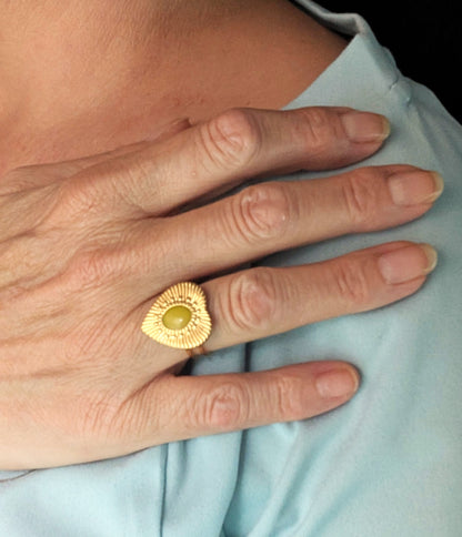 Bague Cœur Doré Lime portée, en acier inoxydable doré avec cabochon en résine vert-jaune lumineux.