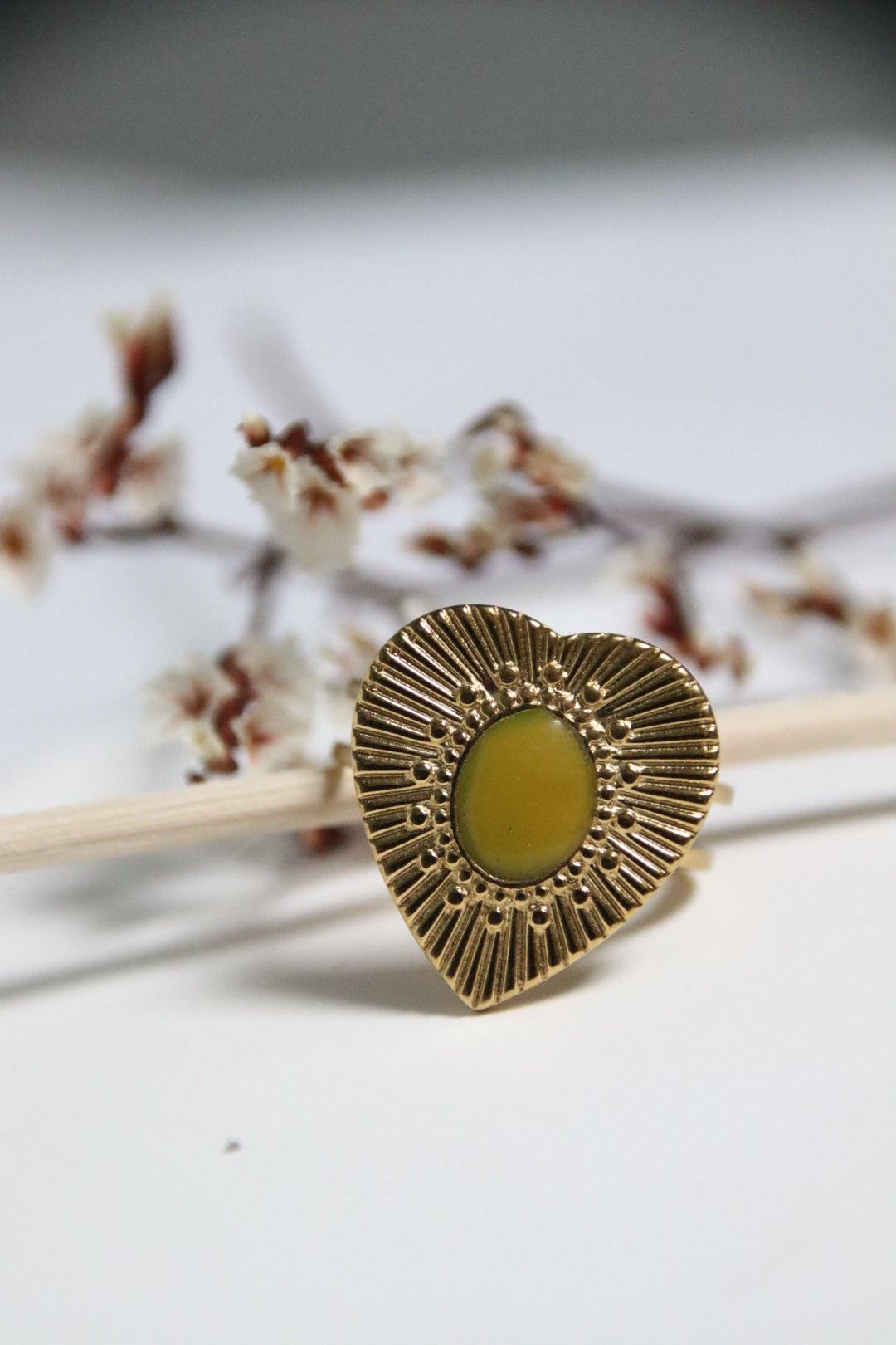 Bague Cœur Doré Lime en gros plan, forme cœur dorée avec cabochon jaune-vert éclatant