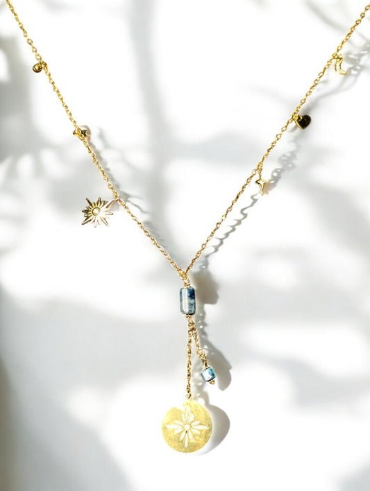 collier Constellation, mettant en valeur ses breloques célestes et sa pierre d’apatite aux reflets vibrants.
